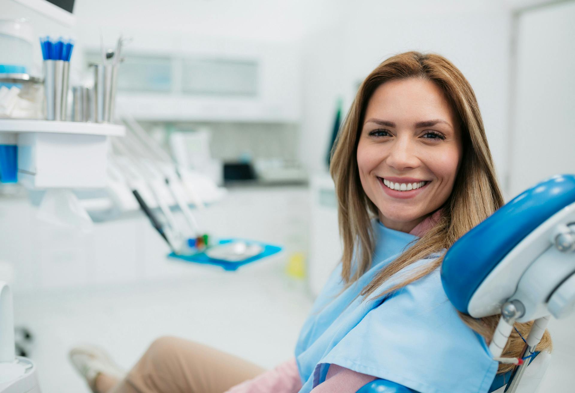 A woman in a dentist chair smiling