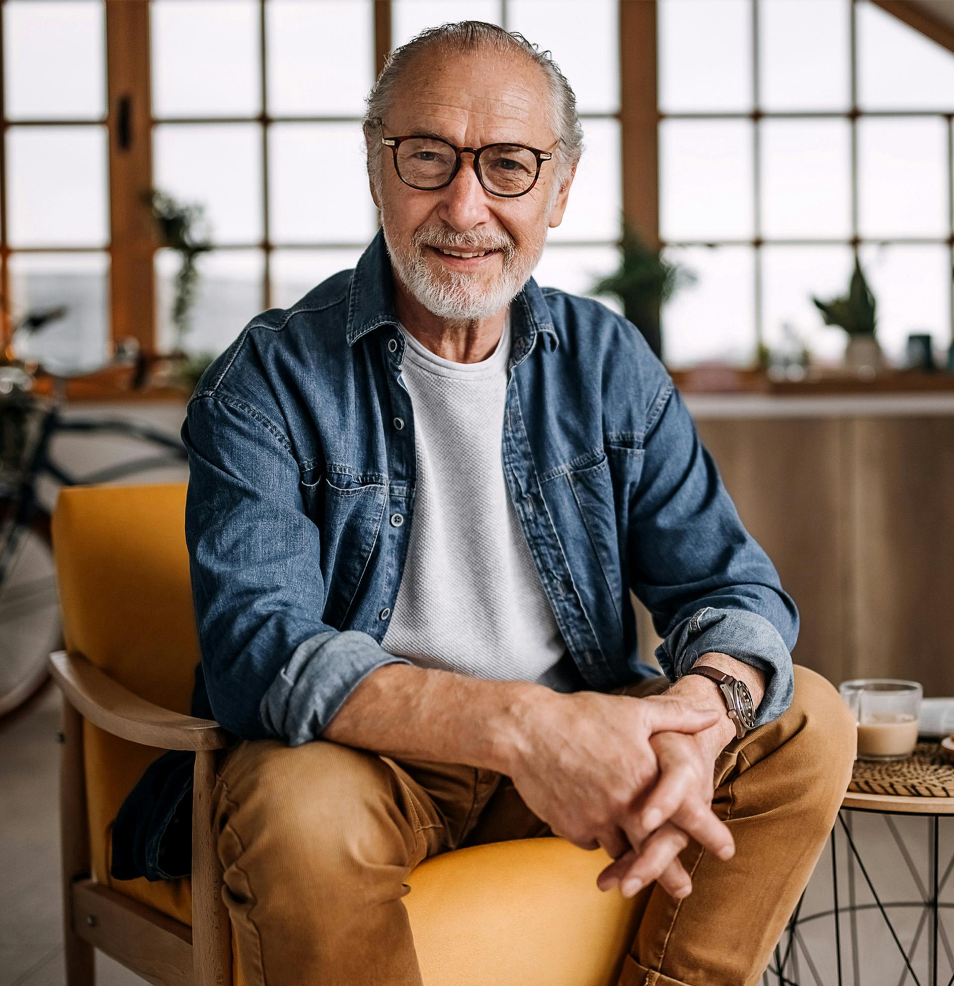 man sitting in a chair with a cup of coffee
