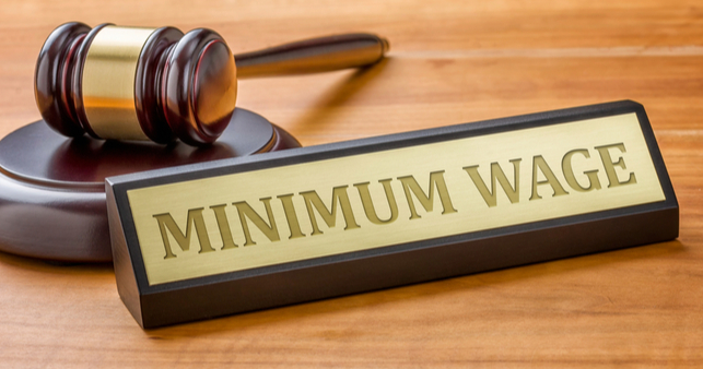 A gavel and a minimum wage plaque on a table