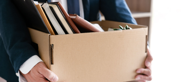 An employee leaving with a box of personal belongings