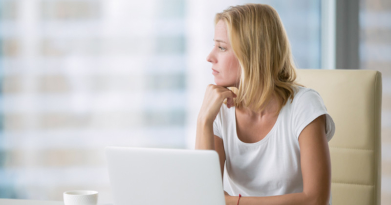 frustrated female corporate employee looking out office window