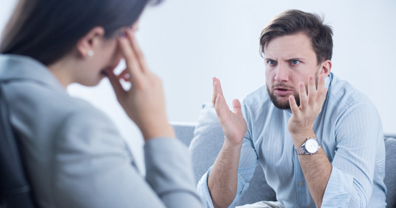 Frustrated male office worker complianing to female coworker