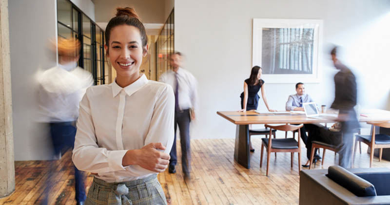 happy female office worker in busy office space