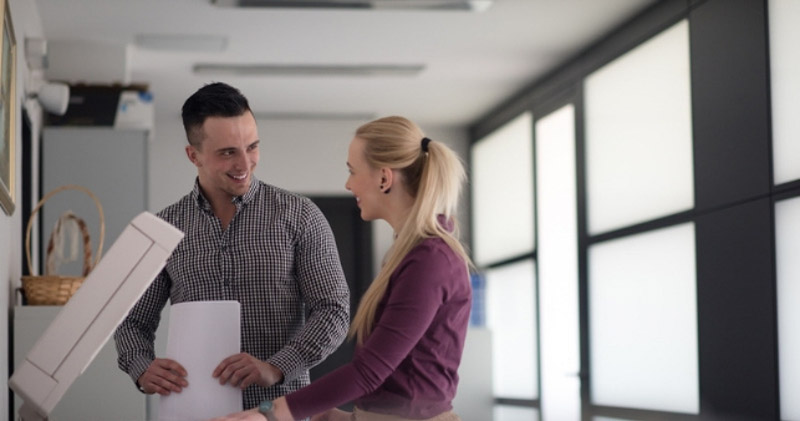 romantically involved male and female coworkers smile at each other