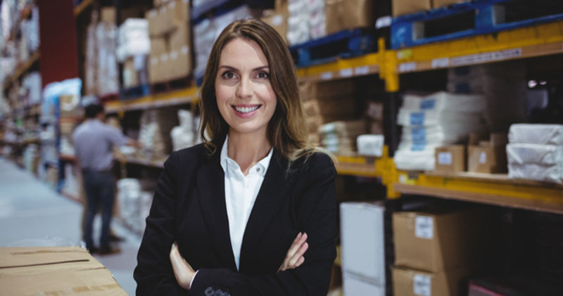 female office worker smiles in warehouse space