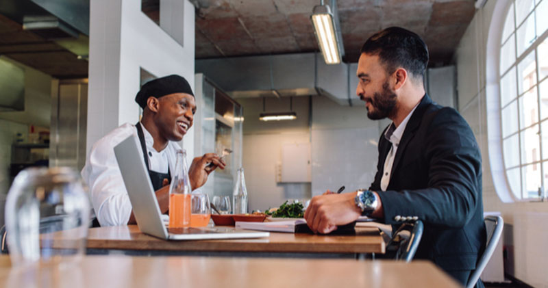 chef and corporate worker catch up over lunch in restaurant