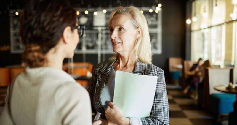 female HR worker meets with young employee in lunchroom