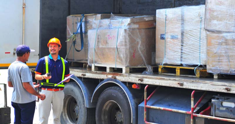 male heavy goods delivery driver cheerfully chats with man