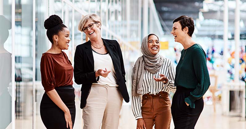 4 female office workers laughing together during break