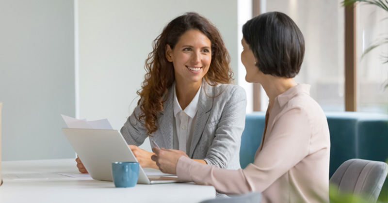 female office manager conducts performance review with female employee