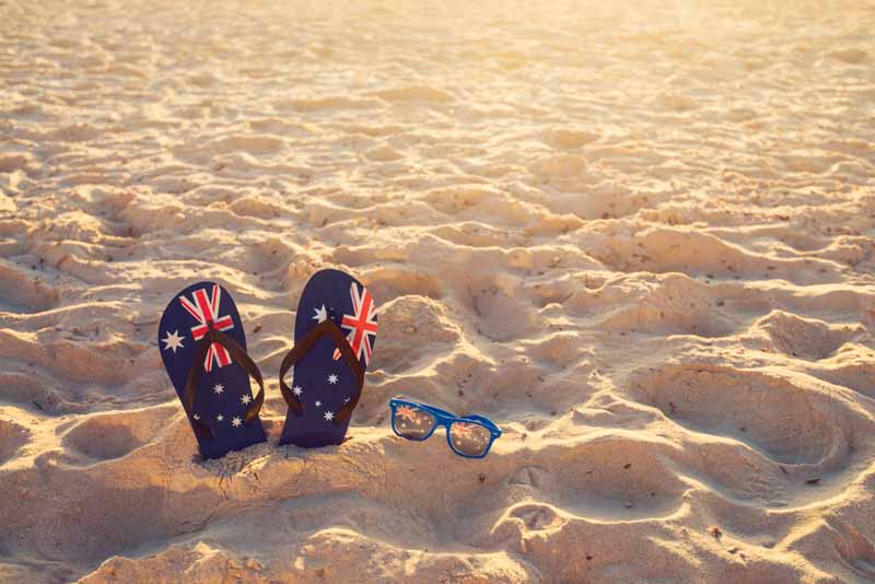 australia flag thongs and glasses on sandy beach