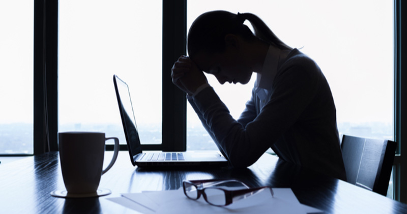 upset female corporate employee in dark boardroom