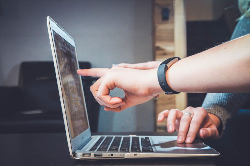 employees examine laptop details together