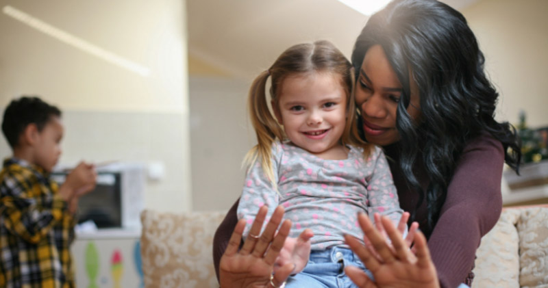 adoptive mother plays with adopted daughter