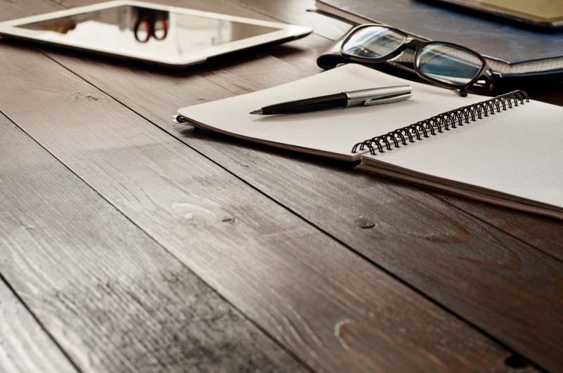 notepad and pen on wooden table