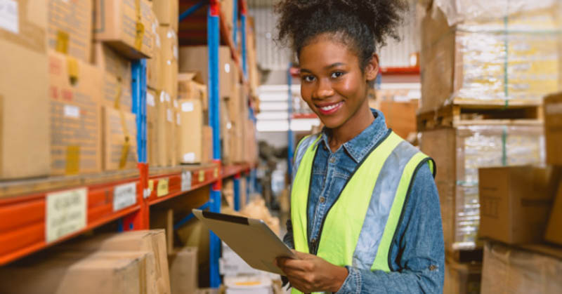 happy female warehouse worker in high vis