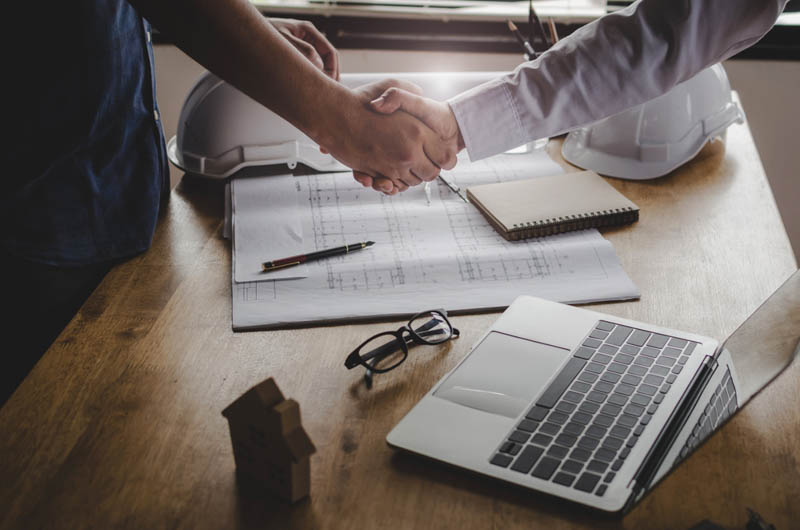 construction boss shakes hand with new worker