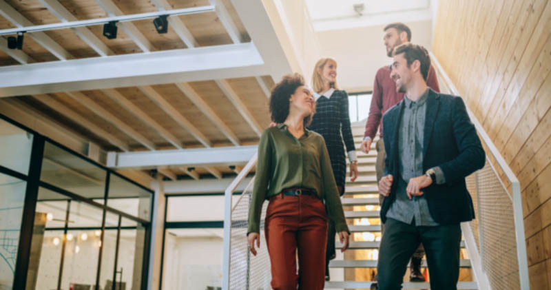 young coworkers walk down stairs in trendy office