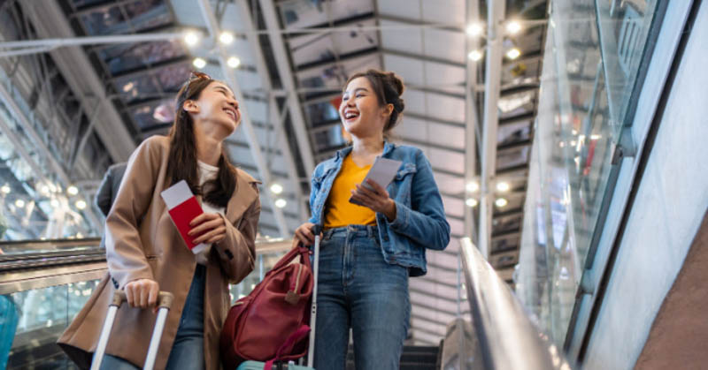 two female friends at airport heading on a trip