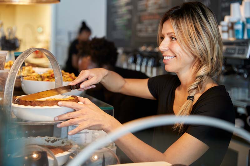 cafe worker serves a piece of pie to customer