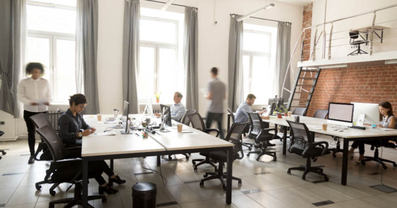 open plan office space with employees at tables