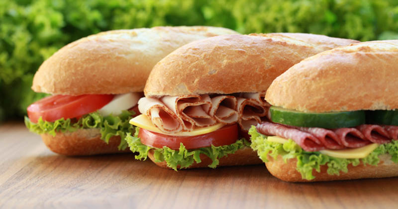 3 submarine sandwiches with cold meat, lettuce and tomato