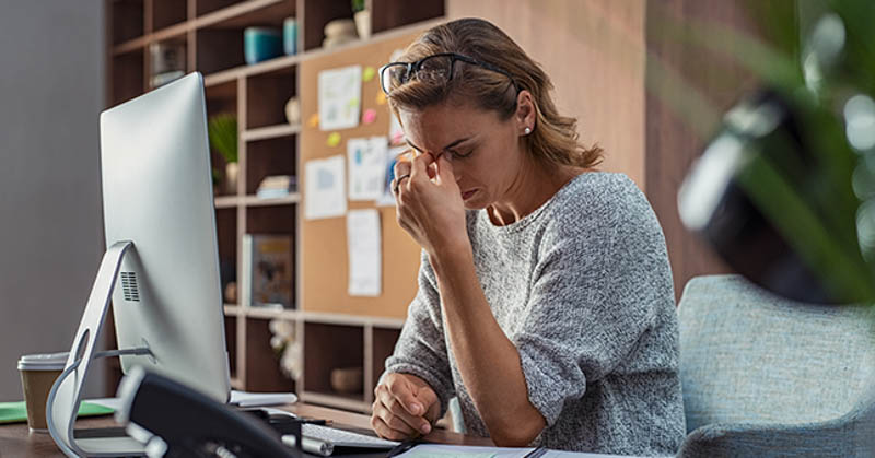flustered burnout of female employee at desk