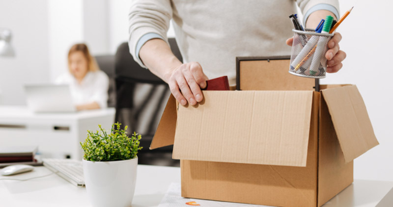 redundant man packs belongings into cardboard box