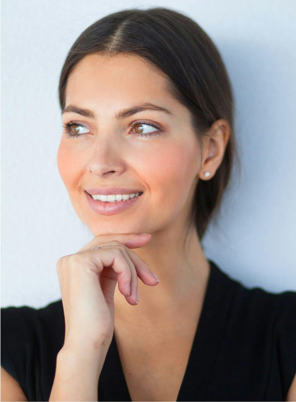 Woman smiling, touching her chin with her hand