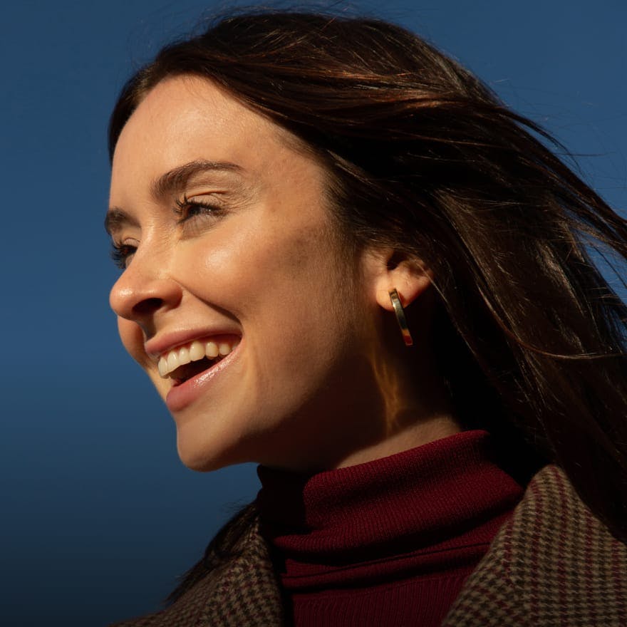 Woman smiling outside with long dark brown hair