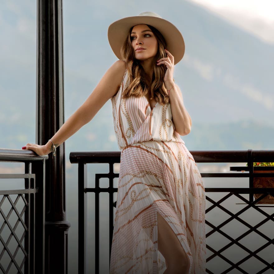 Woman outside wearing a long dress and big hat
