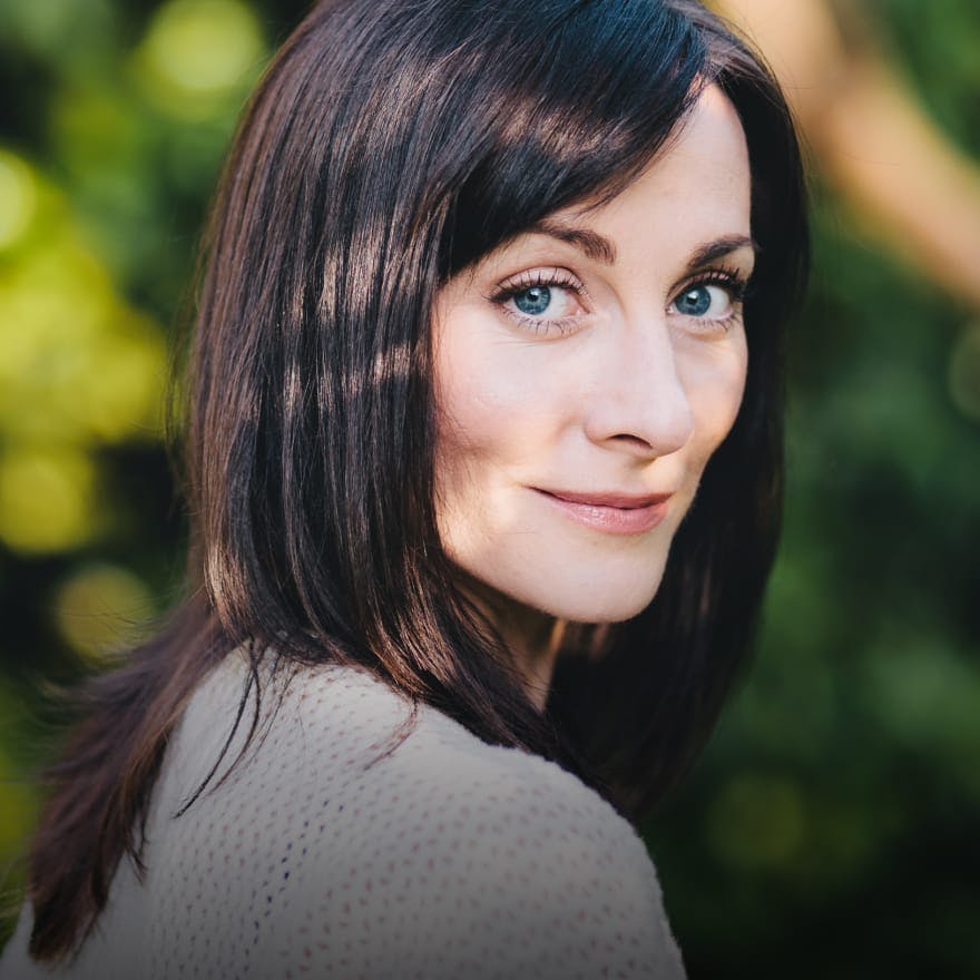 Woman smirking with long dark brown hair