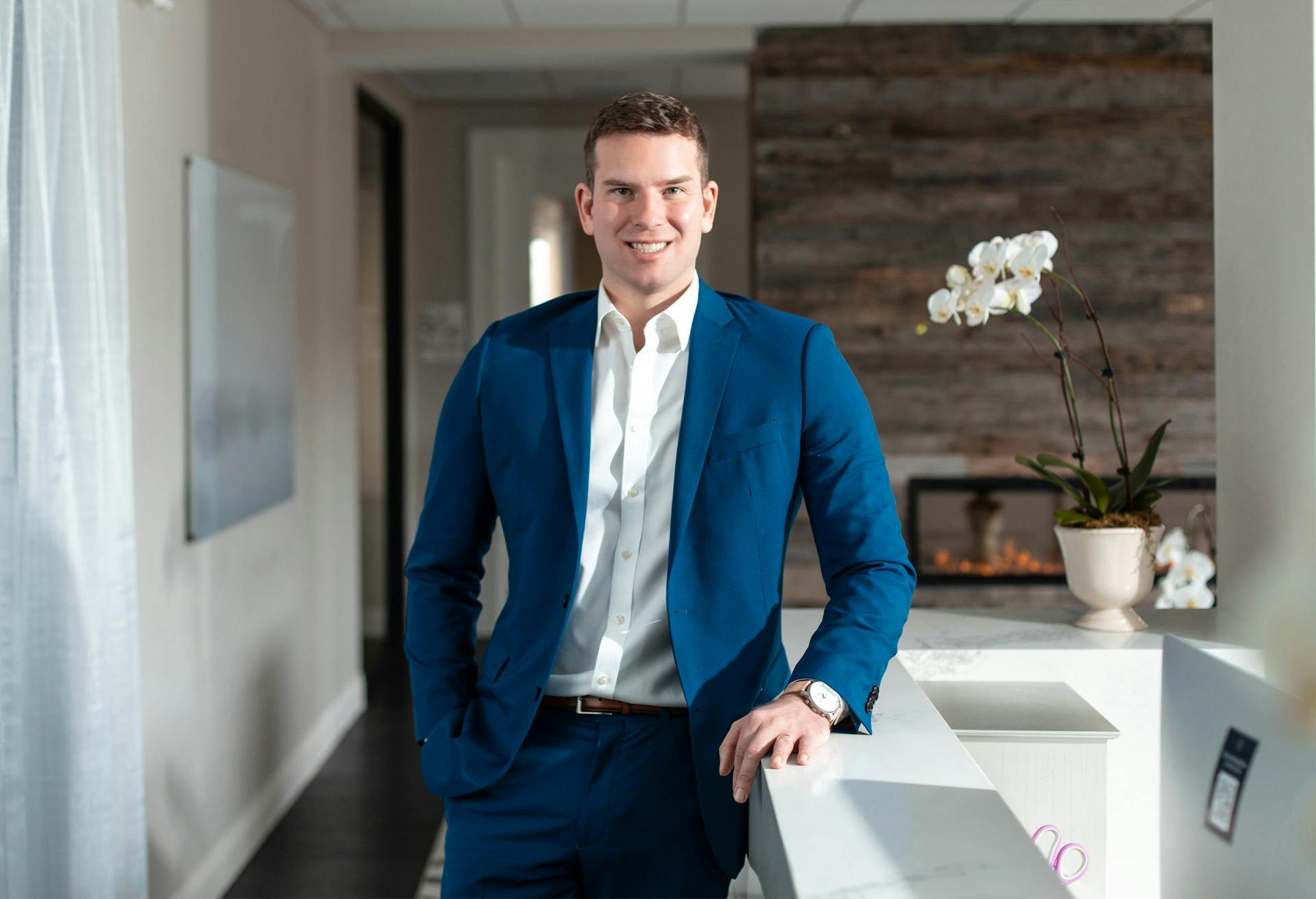 Dr. Gardenier in a blue suit standing by a desk