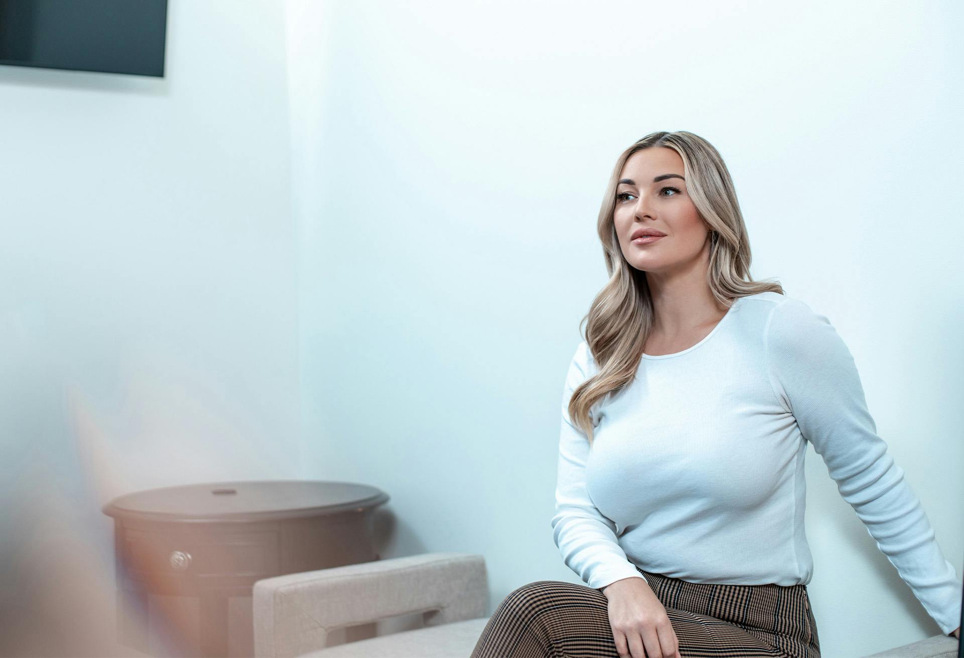 A woman in a white top sitting and leaning back