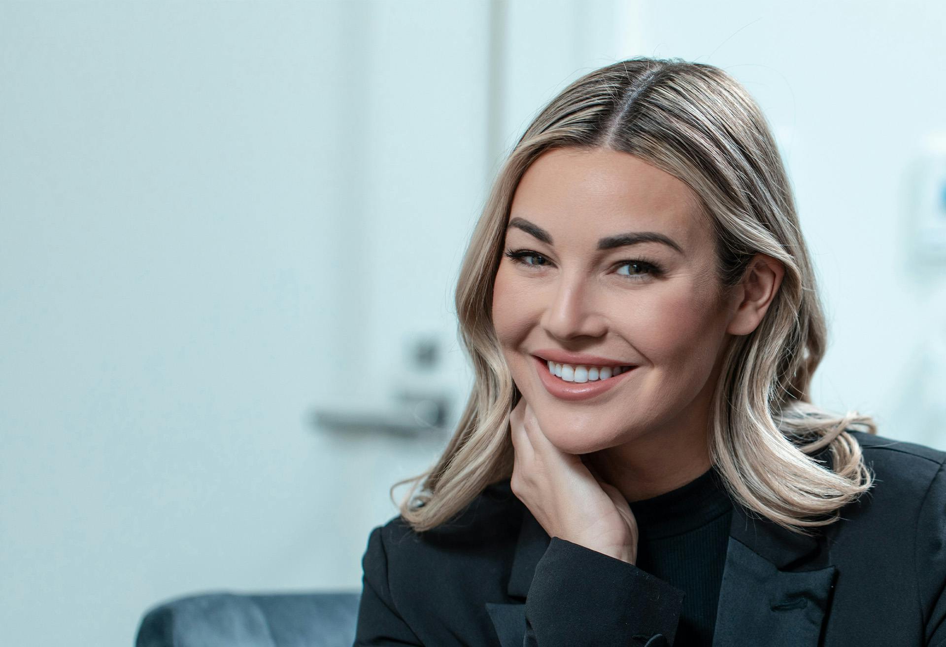 A woman in a black blazer smiling
