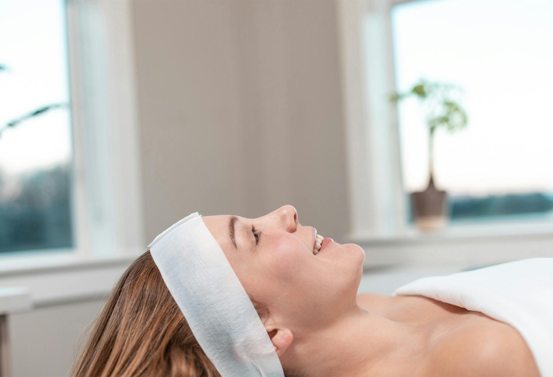 Woman laying down waiting to begin her face procedure