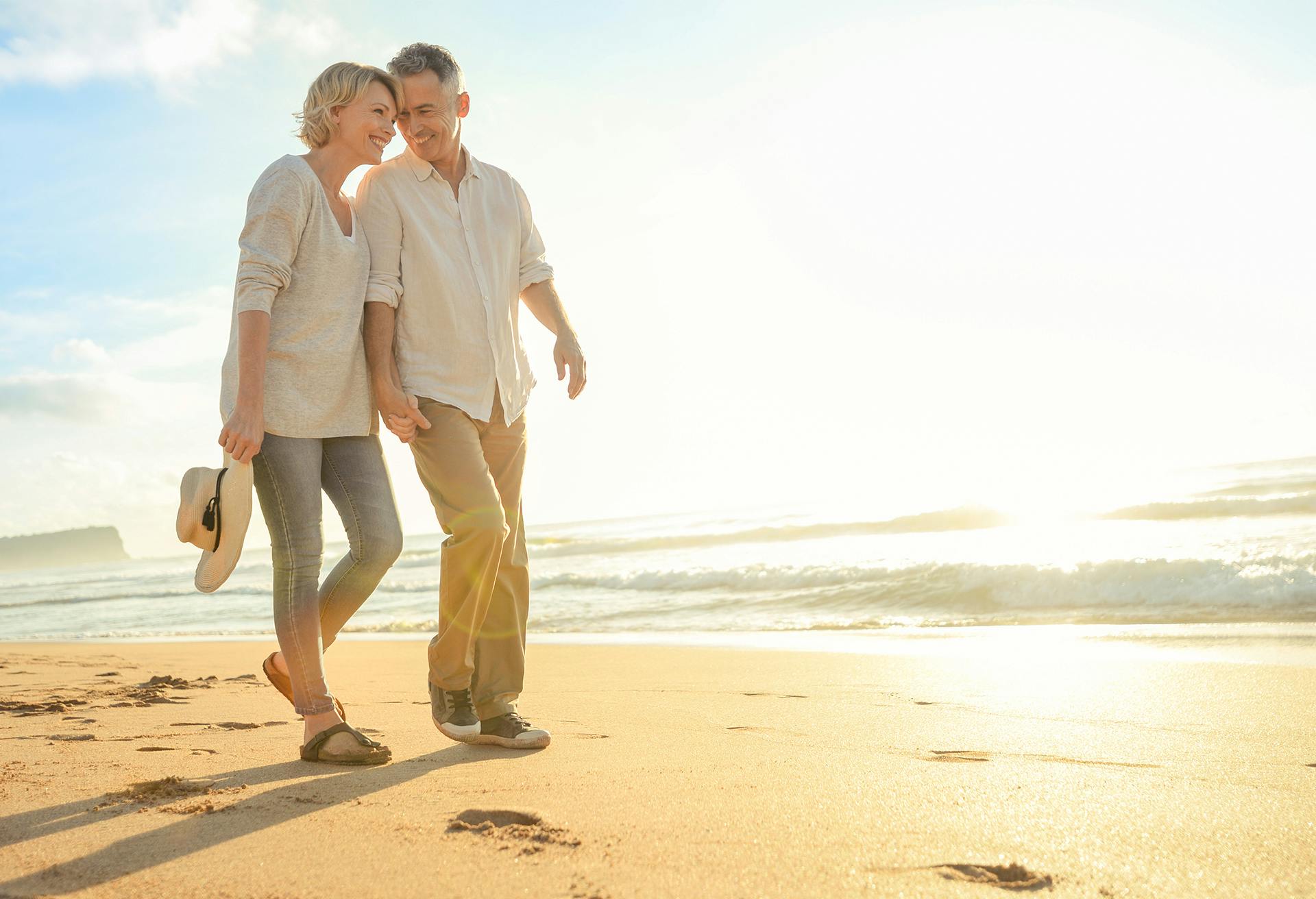 A man and a woman walking on a beach