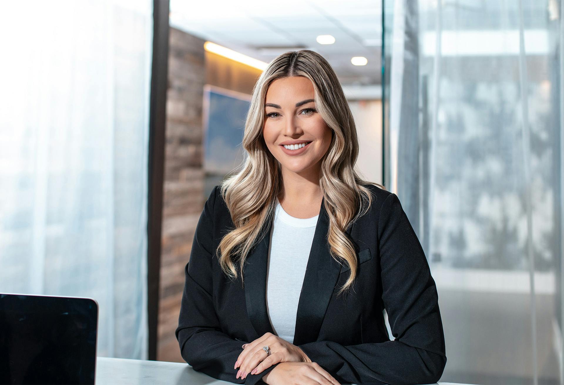 Woman smiling wearing a black suit jacket