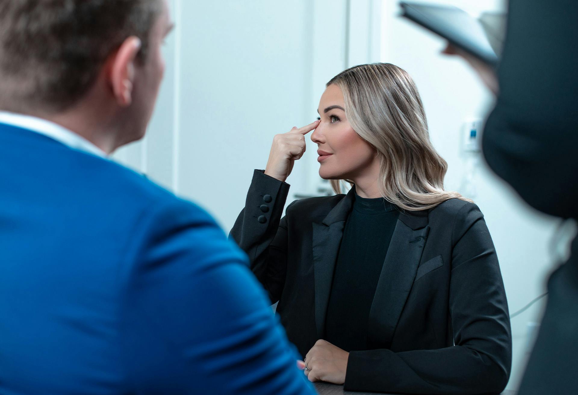A patient pointing to her nose