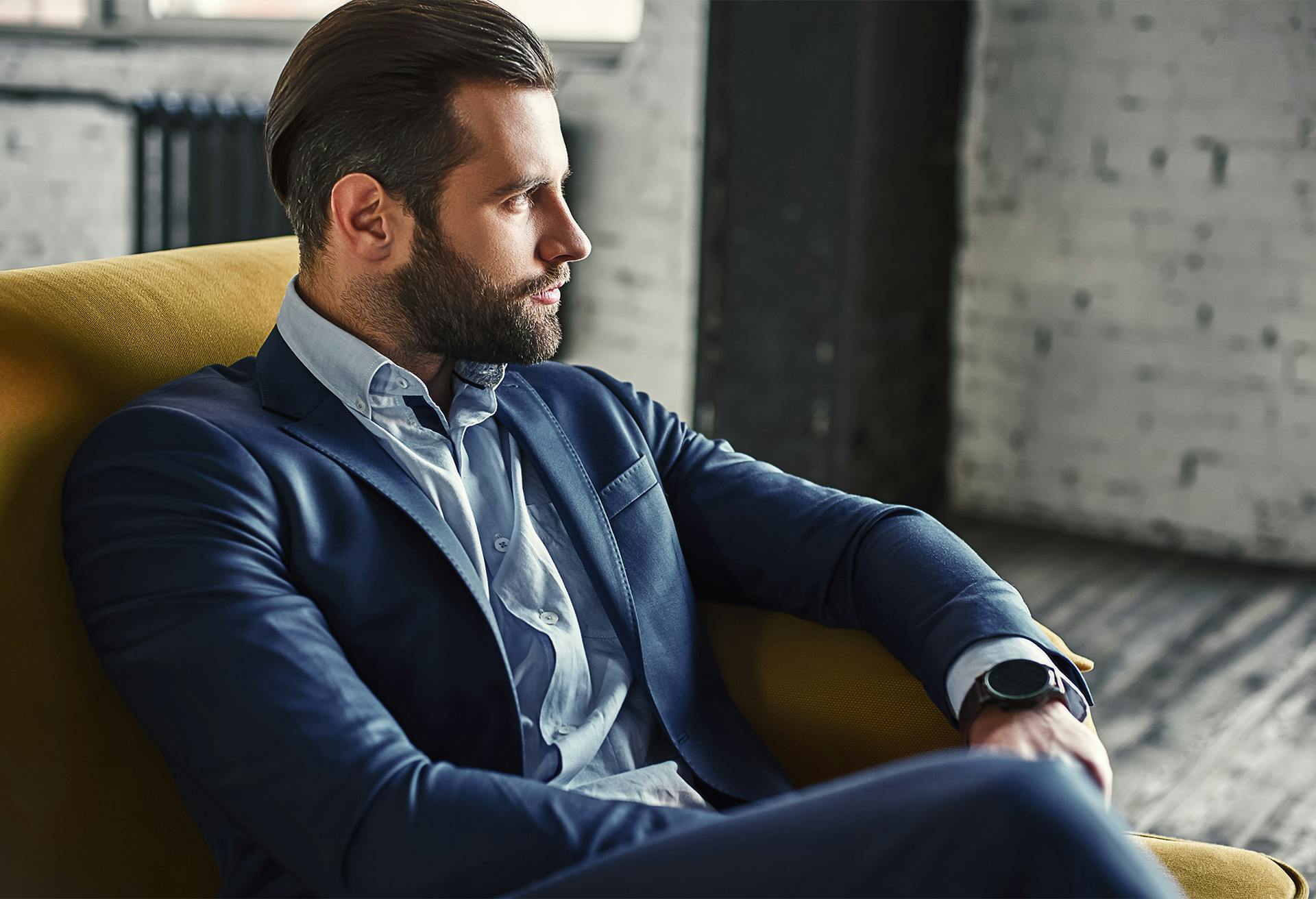 A handsome man sitting in a chair looking to the side