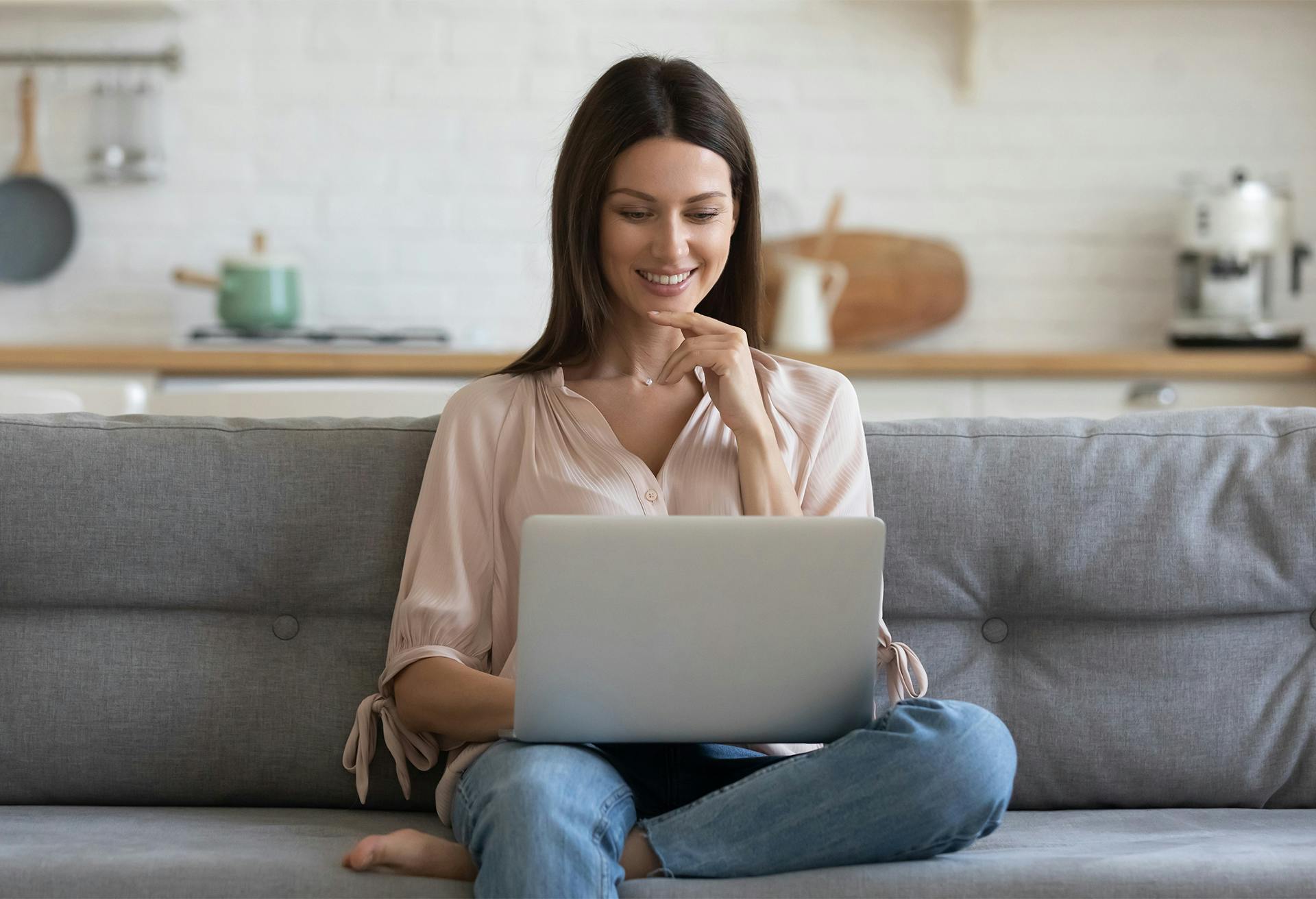 woman sitting on a couch using a laptop computer