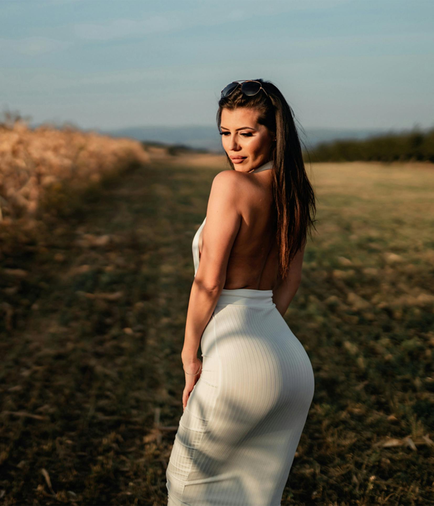 woman in a white dress standing in a field