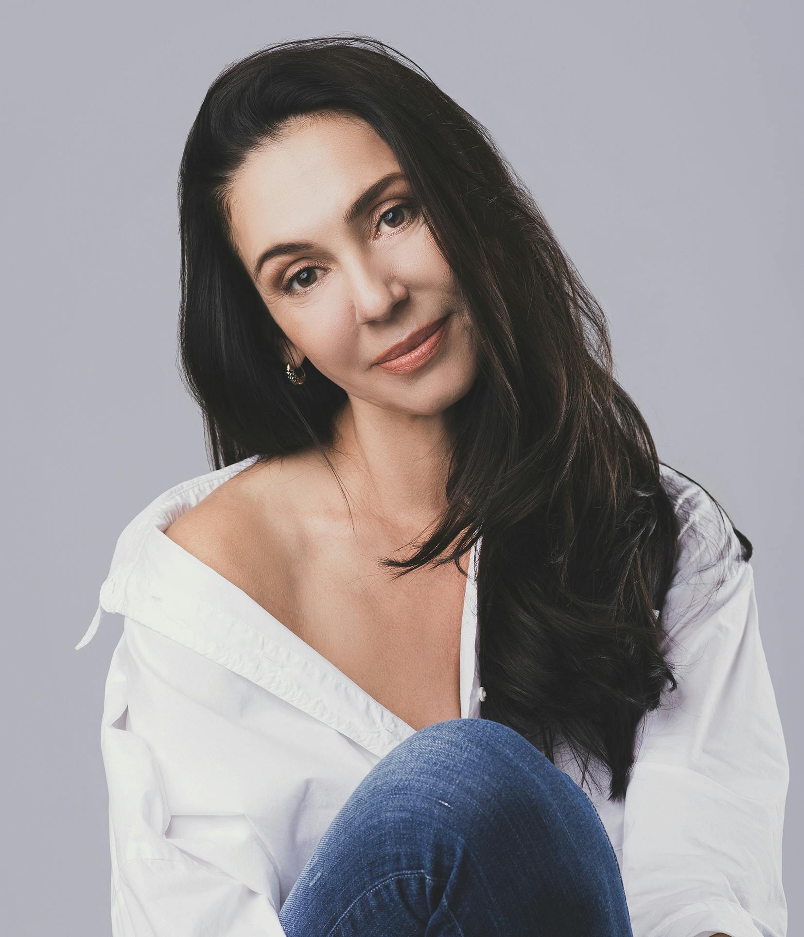 woman with long dark hair sitting on a chair