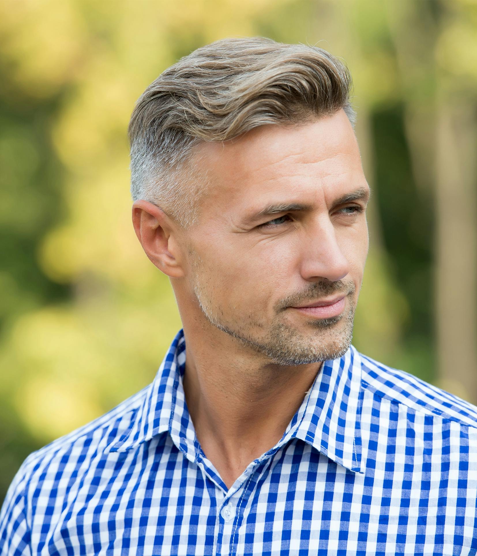 man with a blue and white checkered shirt looking away