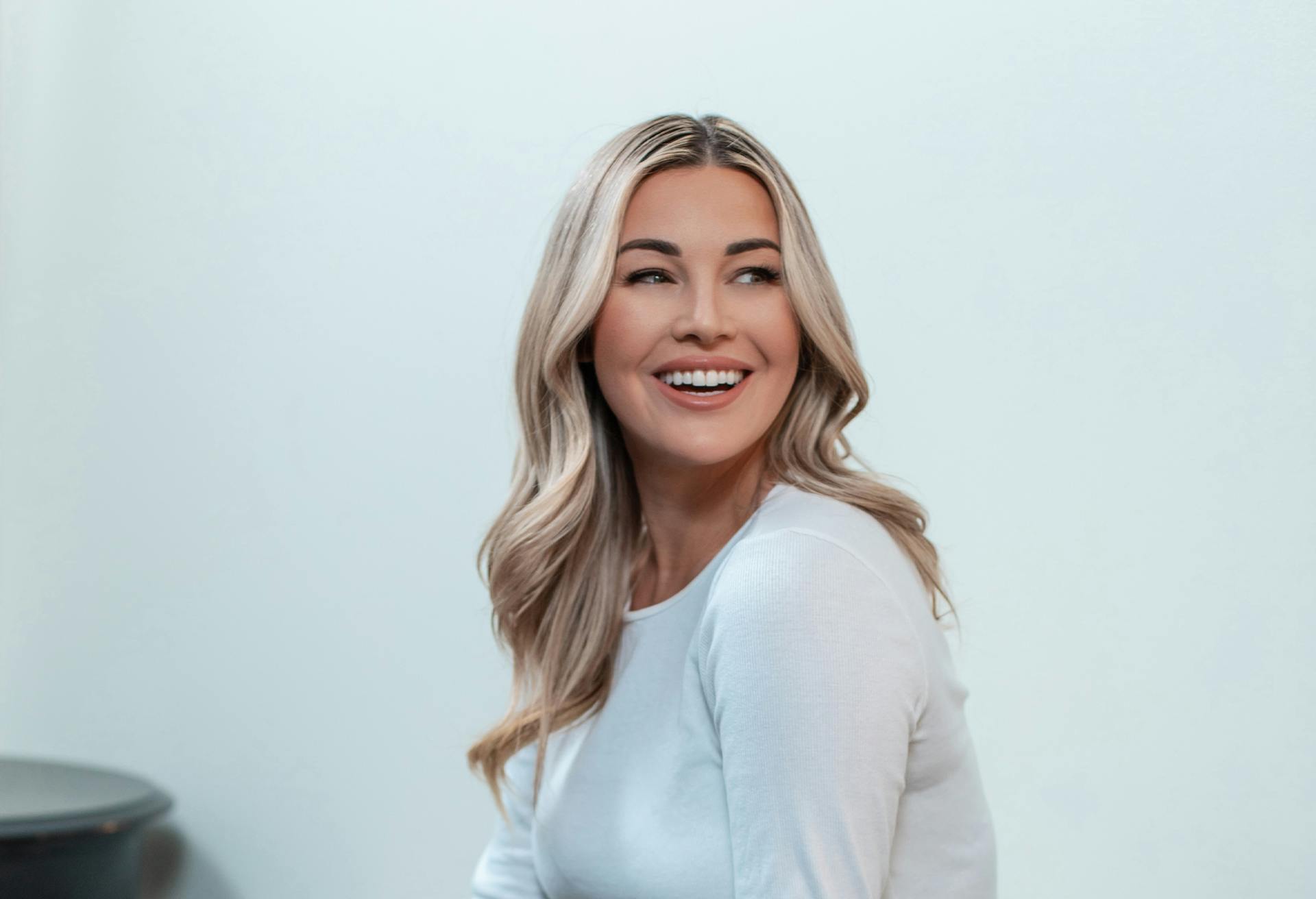A beautiful blonde woman in a white top smiling