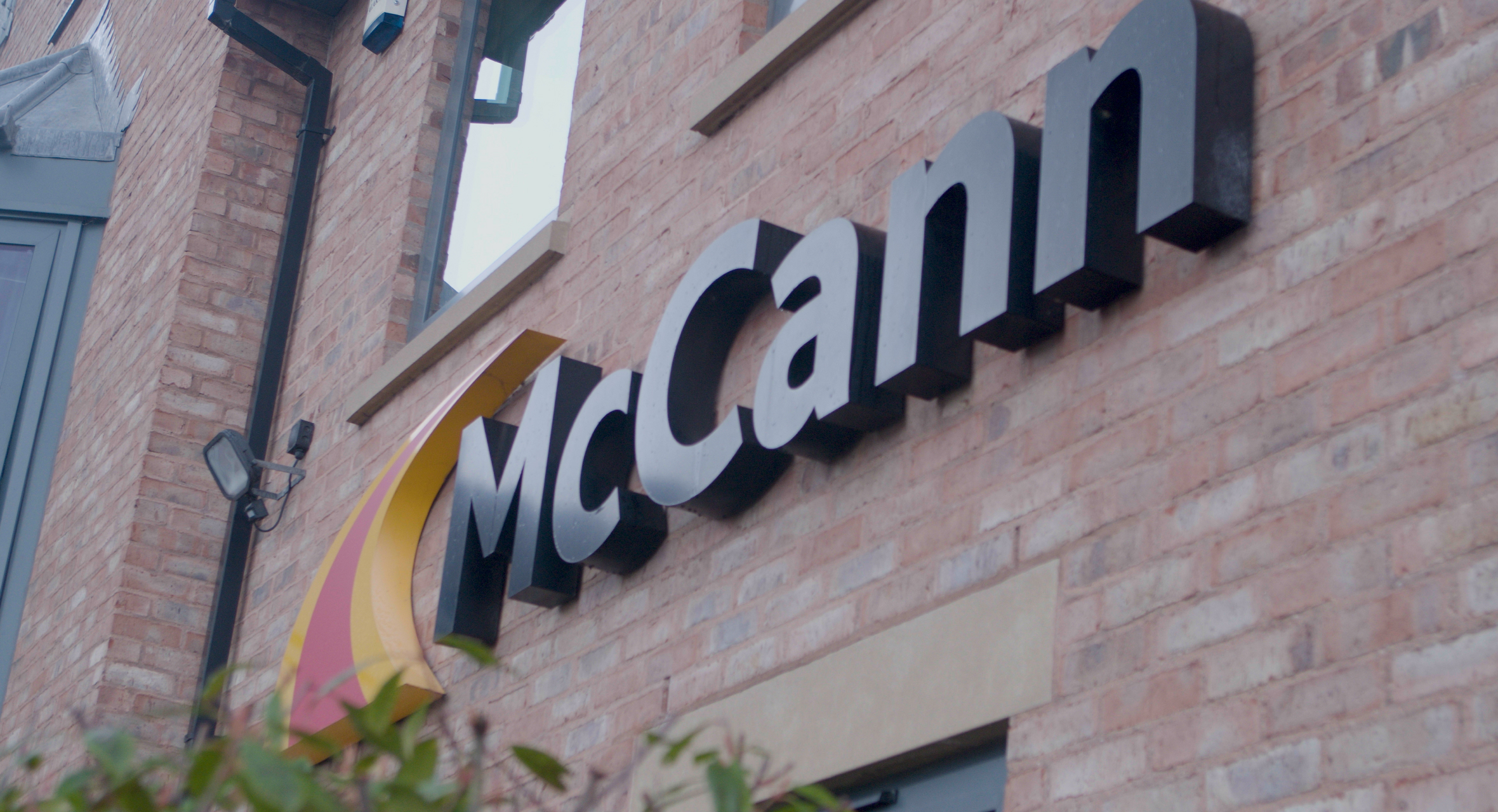 McCann Ltd. office building with black logo on wall