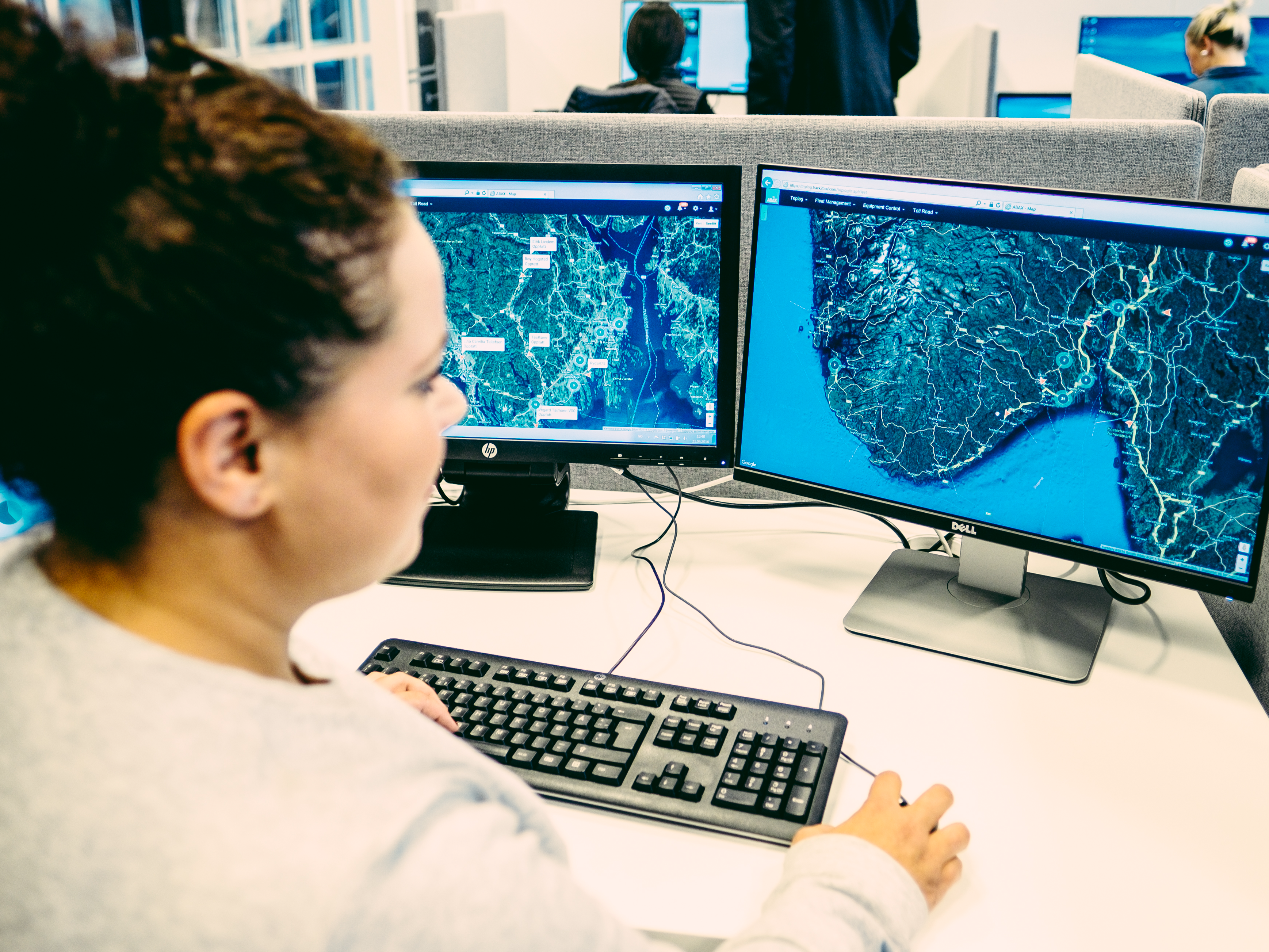 Woman managing fleet on computer screen which shows a map