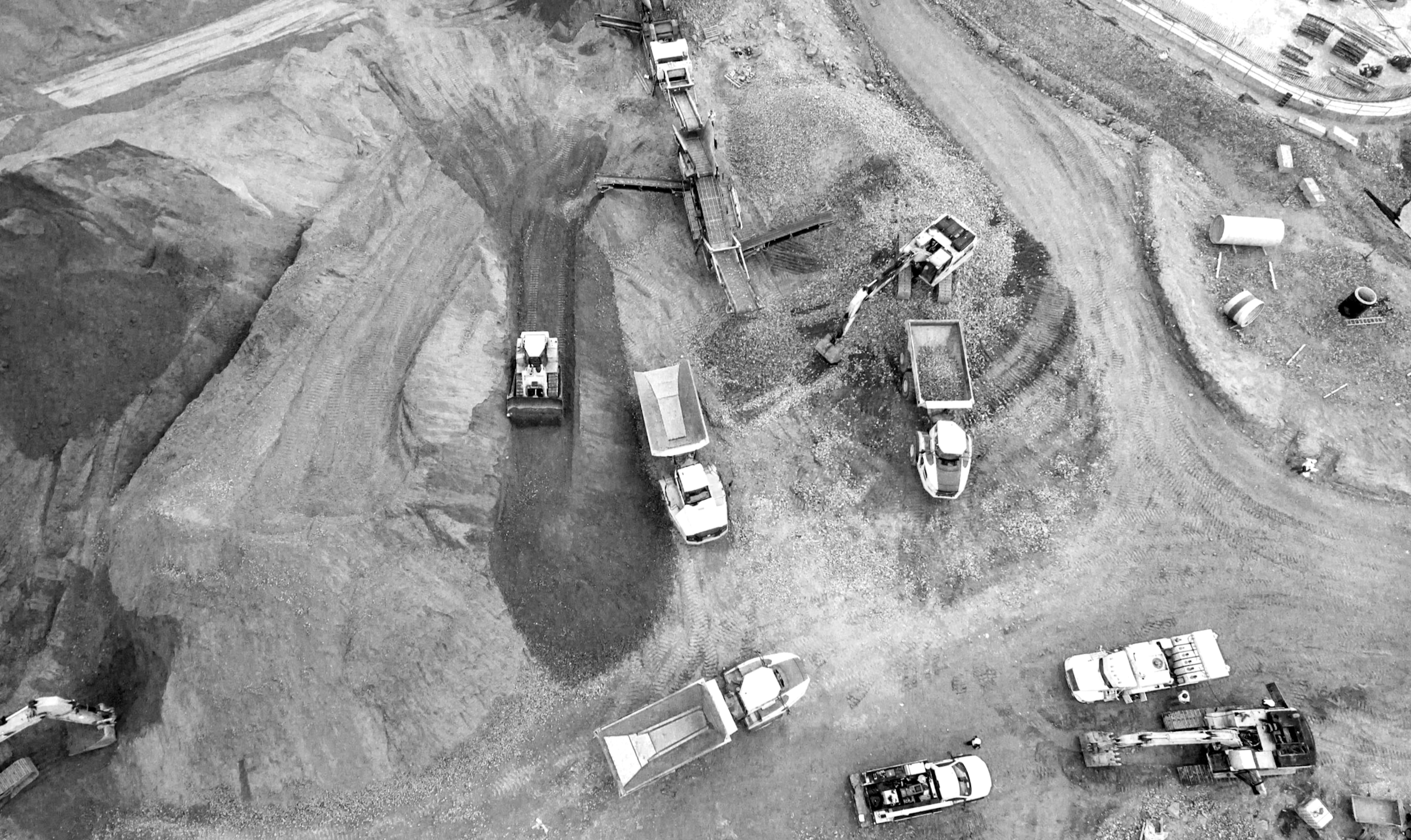 Building site with multiple plant and machinery in black and white