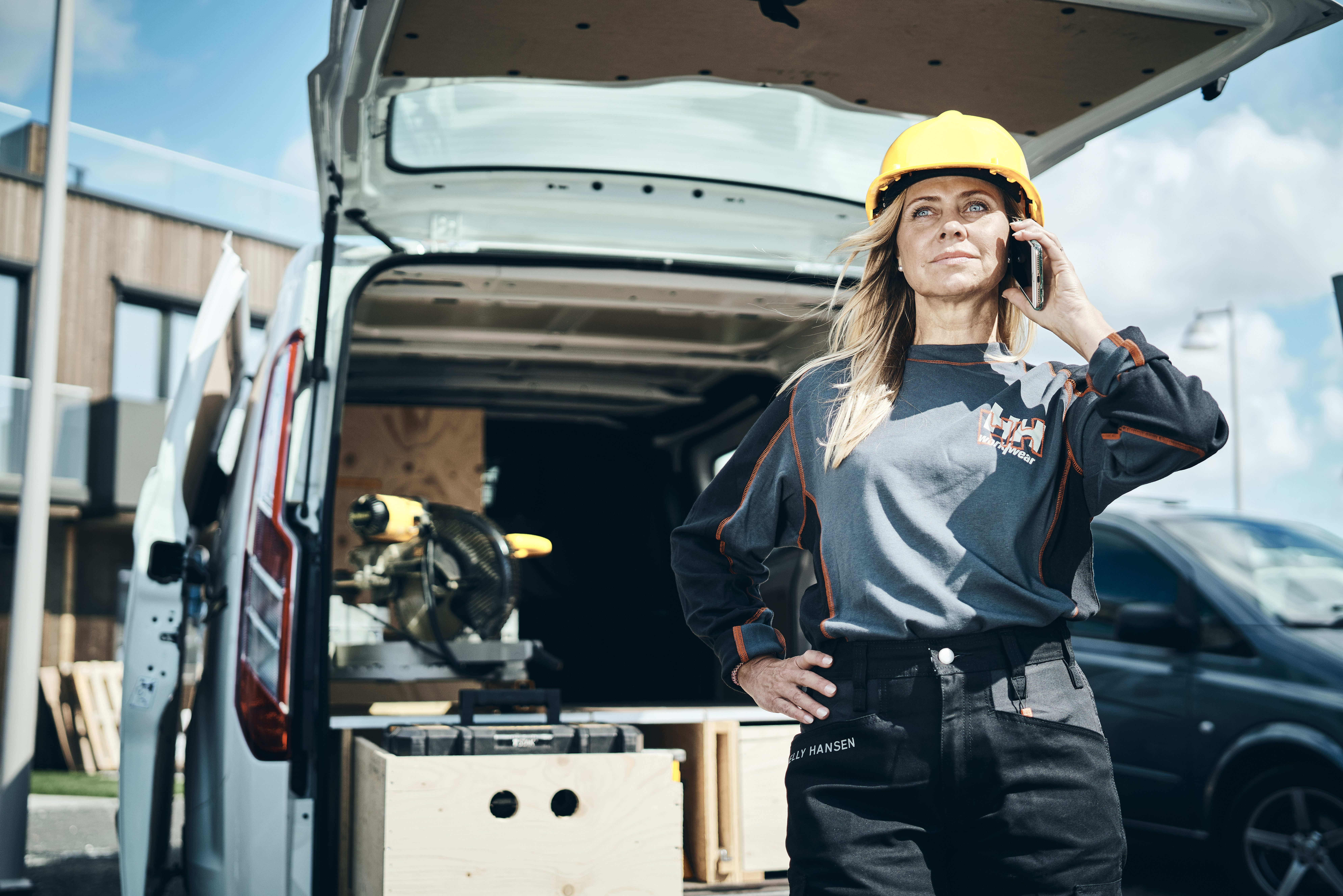 Worker woman talking on the phone in front of a van