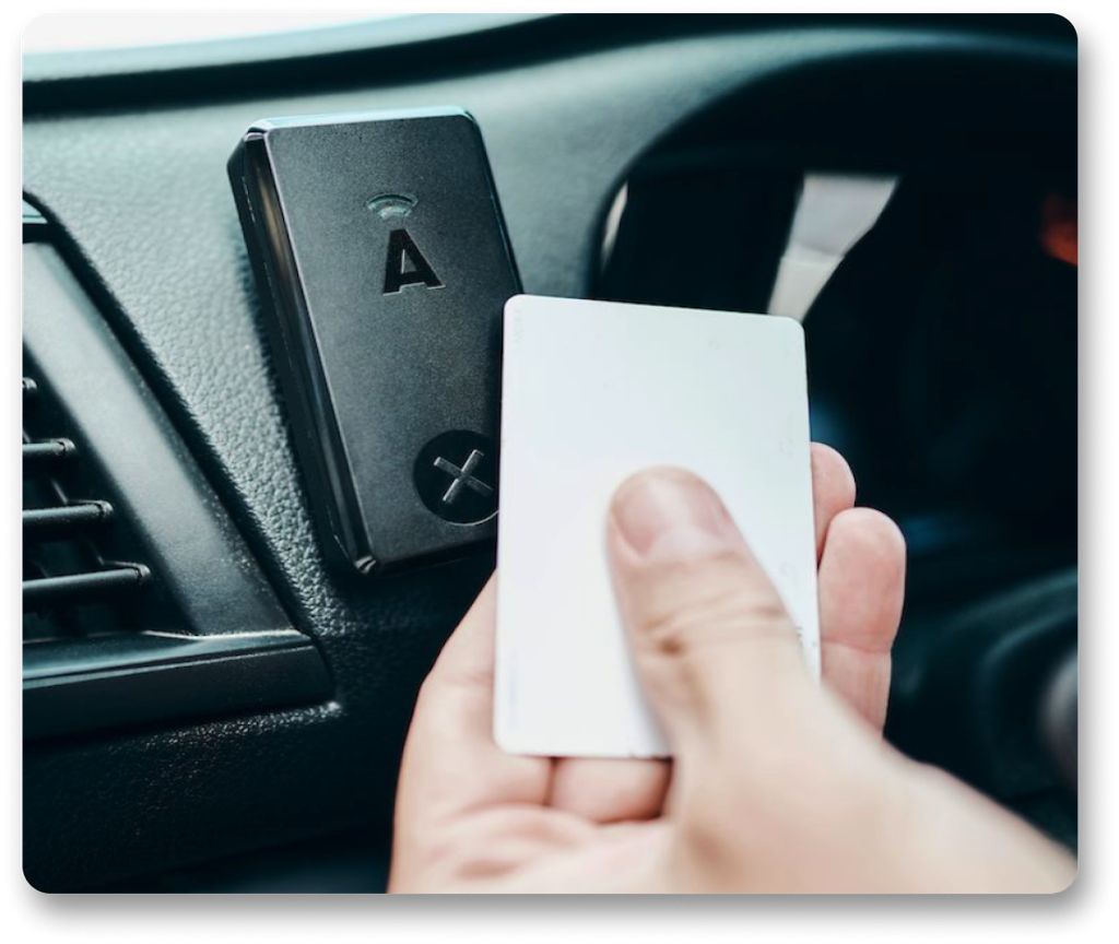 Person scanning into a car with ABAX Driver ID RFID reader and white card